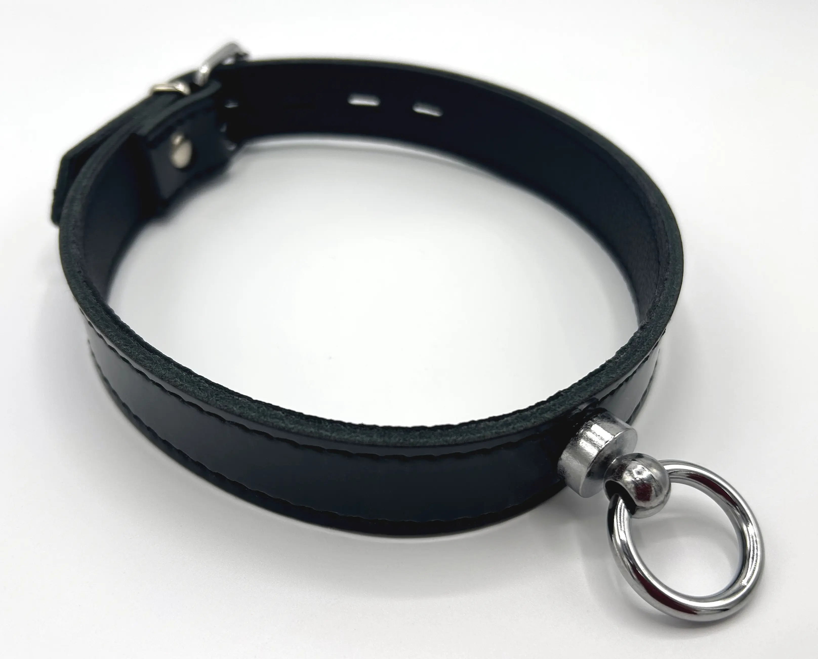 Nahaufnahme des silbernen Rings der O am schwarzen Lackhalsband