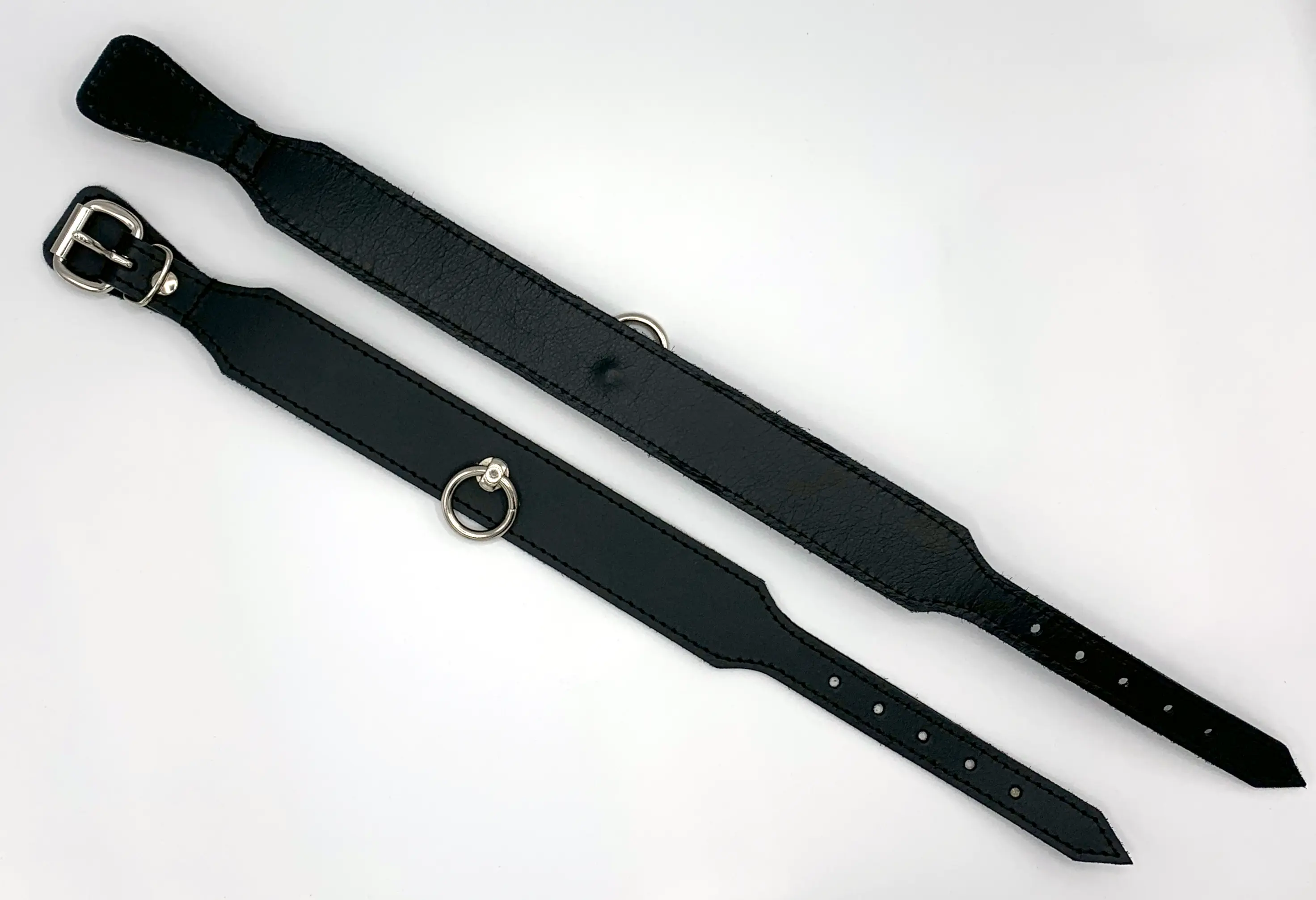 Schwarzes Lederhalsband in zwei Größen flach liegend mit Dornschnalle und O-Ring